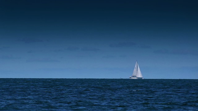 Boat Sailing on Open Blue Sea on Bright Summer Day