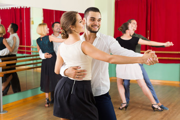 men and women enjoying of tango in class