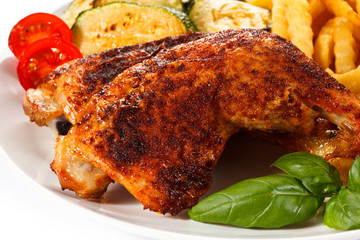 Grilled chicken legs with chips and vegetables 