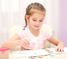 Cute smiling little girl drawing with paint