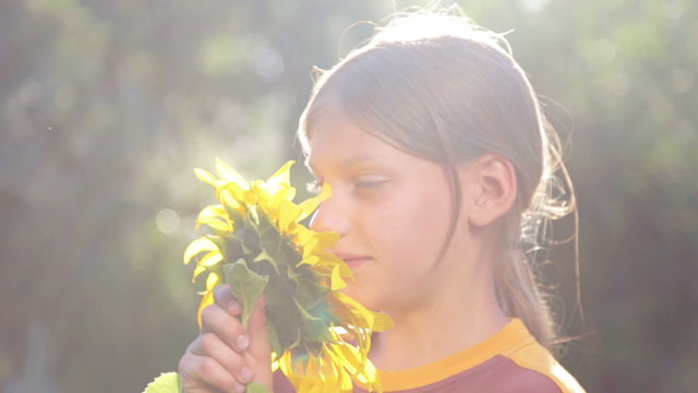 Teenage Boy smelling a flower sunflower.
