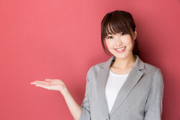 portrait of asian businesswoman pointing on red background