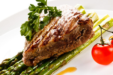 Grilled beefsteak and asparagus on white background