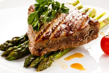 Grilled beefsteak and asparagus on white background