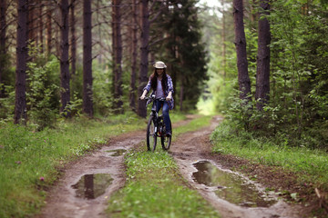 Fototapeta premium young girl on a sports bike in a summer forest