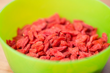 Dried goji berries in green bowl