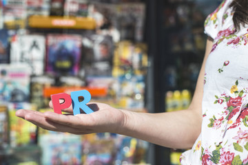Women hold wooden letters PR