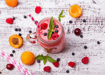 Berries and fruits smoothie in a glass mug