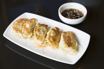 Jiaozi or gyoza, Chinese dumpling on black table with  sauce