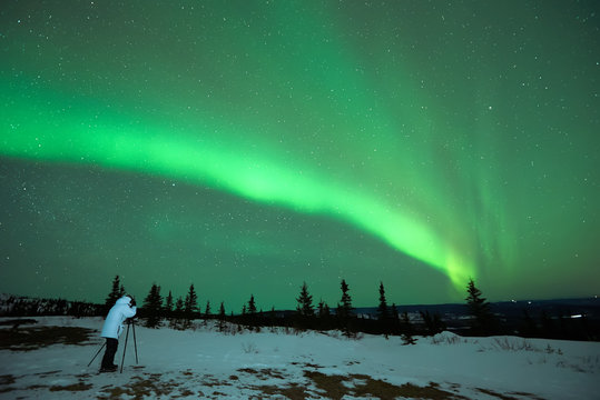 Man photographing the Aurora Borealis in Alaska
