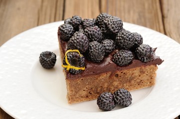 Piece of tasty chocolate pie with ganache, decorated with fresh