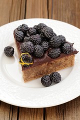 Piece of tasty chocolate pie with ganache, decorated with fresh
