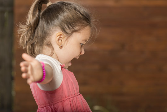 Outdoor portrait of expressive beautiful little girl smiling astonished