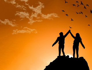 friends on Top of a Mountain Shaking Raised Hands