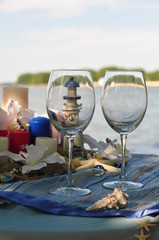 Glasses are on the festive table in the style of the wedding in the marine theme.