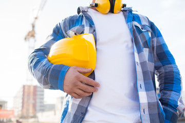 close up of builder holding hardhat on building