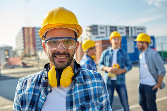 smiling builder with hardhat and headphones