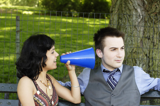 Man ignoring woman with megaphone.