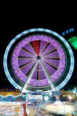 Obraz premium Colorful ferris wheel in motion at night