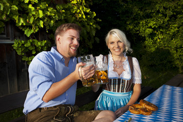 Happy bavarian couple in beer garden