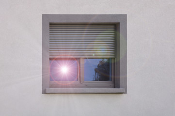 Hitzeschutz durch Rollladen und Fenster mit sich spiegelnde Sonne