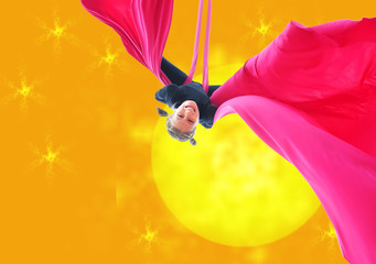 child hanging upside down on aerial silks