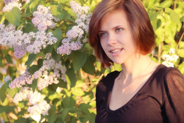 Naklejka premium Spring portrait of a young girl in a park outside
