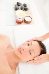 Obraz na płótnie Canvas Attractive young woman receiving head massage at spa center