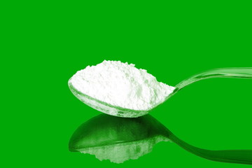 natural sugar powder in  spoon in green background
