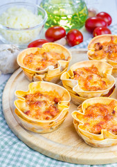 Homemade lasagna cups with minced meat, bolognese sauce topped with cheese