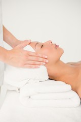 Obraz na płótnie Canvas Attractive young woman receiving facial massage 