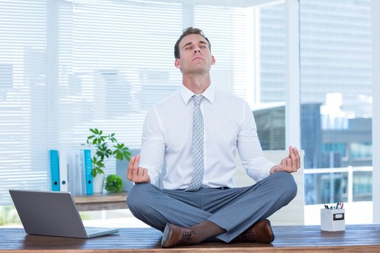 Zen businessman doing yoga meditation