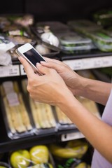 Woman reading her shopping list on smartphone