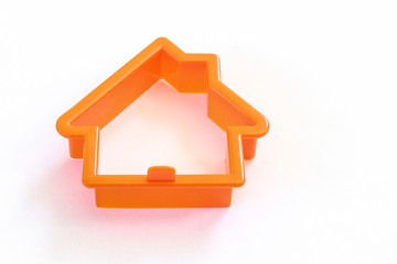 Orange plastic cookie cutter of a home
