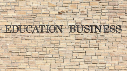 Fototapeta na wymiar Education Business spelled out on a stone wall