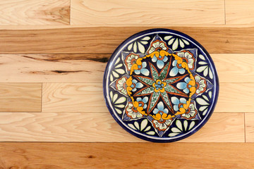 Blue pattern Mexican talevera plate on hickory wood