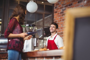 Handsome barista discussing with a customer