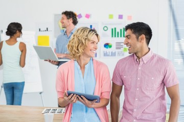 Obraz premium Casual businesspeople using digital tablet with colleagues
