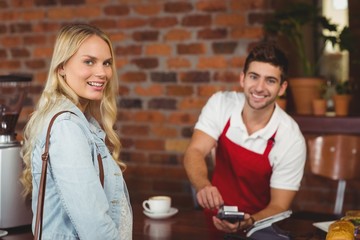 Smiling waiter using the pin terminal 