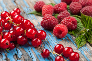 Red currant and raspberry on wooden surface