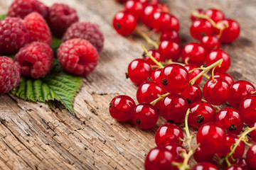 Red currant and raspberry on wooden surface