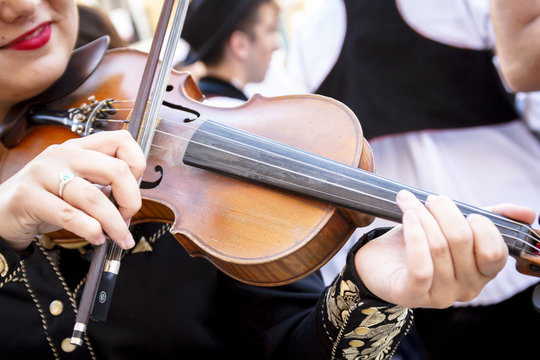 M&uacute;sico tocando el viol&iacute;n en la calle. Violinista dando recital en el exterior. Primeros planos de un viol&iacute;n. Mariachi amenizando evento.