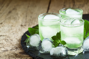 Green cold drink with ice in a heart shape, selective focus