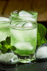 Green cold drink with ice in a heart shape, selective focus