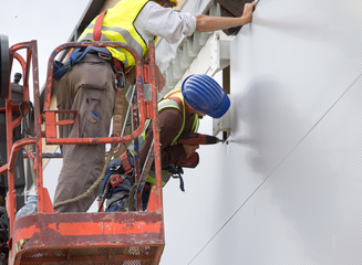 Workers installing facade panels
