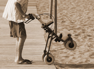 man walking with Walker on the beach in summer