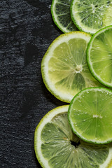 Fototapeta na wymiar Sliced lemon and lime on a dark background, top view, selective