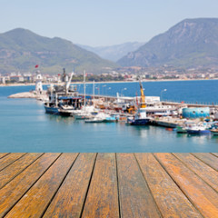 Empty wooden table for product presentation. In the background blurred ships and boats in the port