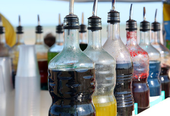 bottles of colored syrup for preparing ice creams in summer on t