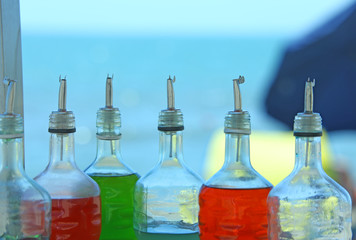many bottles of colored syrup for preparing ice creams on the be